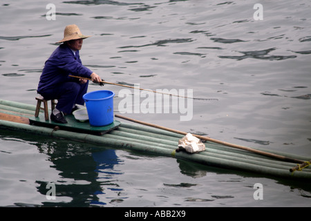 Alter Mann Angeln von einem Floß im Fluss Lee, Yangshuo, China Stockfoto