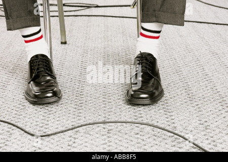 Füße, gekleidet in weißen Socken und schwarze Schuhe Stockfoto