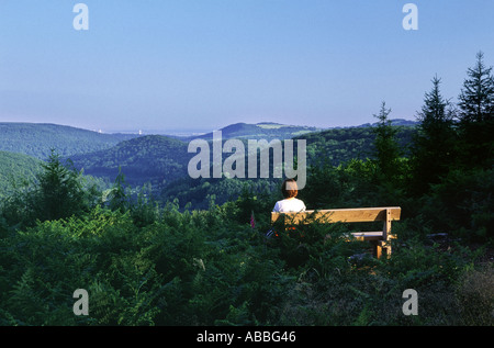 Eine junge Frau entspannt auf einer Holzbank, bewundern Sie die Aussicht über die schöne Wye Valley in der Nähe von Monmouth Stockfoto