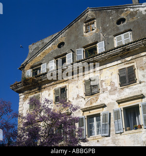 Außenseite des verfallenen lokalen Herrenhaus mit krummen Fensterläden und Peeling-Lackierung in Korfu die griechischen Inseln Griechenlands Stockfoto