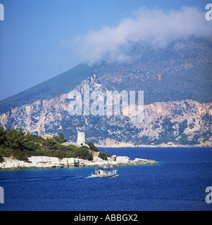 Boot Reisen, um Eingang mit Turm auf Felsen und Ithaca Berge hinter Fiscardo Kephallonia griechische Inseln Griechenland Hafen Stockfoto