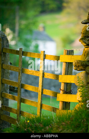 ein traditionelles Lakeland Bauernhaus am Loughrigg Tarn, in der Nähe von Ambleside, Lake District, Großbritannien, gesehen durch ein Hof in der Abenddämmerung Stockfoto