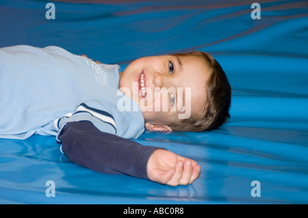 Junge liegt auf dem Boden und lacht Stockfoto