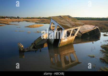 Ein versunkenes Wrack am Dornweiler an der Küste von Norfolk bei Flut, wenn das Meer die Salzwiesen überflutet. Stockfoto