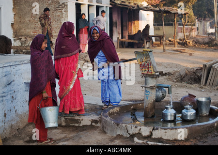 Frauen mit bunten Sari sammeln Wasser mit einer Pumpe gut Jaipur Rajasthan Indien Stockfoto