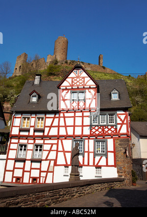 Statue von John der Apostel auf der Brücke vor eine halbe Fachwerkhaus Ferienhaus in Monreal mit Schloss Löwenburg Stockfoto