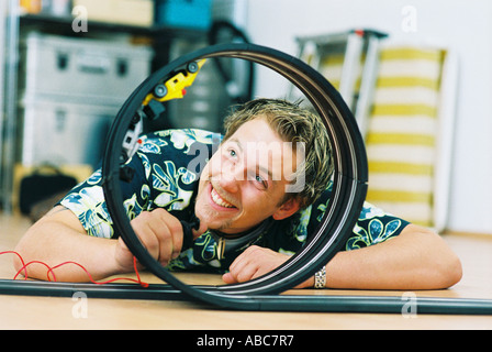 Junger Mann spielt mit Spielzeug Auto speedway Stockfoto