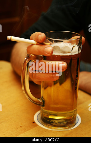 Hand hält einen Zigarette und Bier-Becher Stockfoto