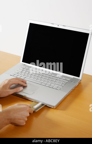 Frauen setzen eine Kreditkarte innerhalb der cd Rom Eröffnung eines Laptop-Computers Stockfoto
