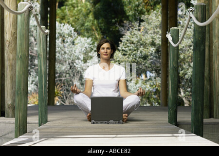 Frau mit Computer tun yoga Stockfoto