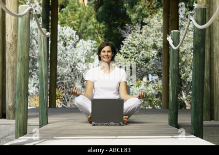 Frau mit Computer tun yoga Stockfoto