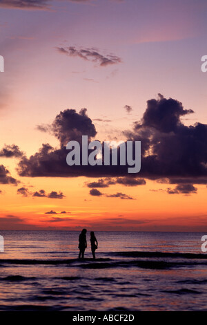 Paar im Meer bei Sonnenuntergang Stockfoto