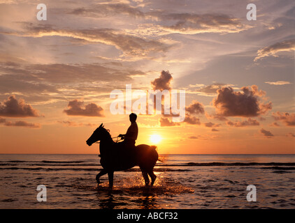 Person, Reiten im Meer bei Sonnenuntergang Stockfoto