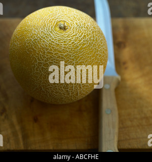 Galia Melone mit Messer Stockfoto