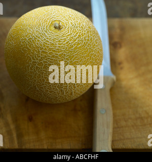 Galia Melone mit Messer Stockfoto