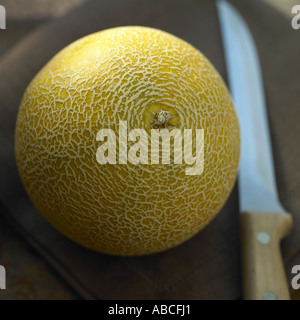 Galia Melone mit Messer Stockfoto