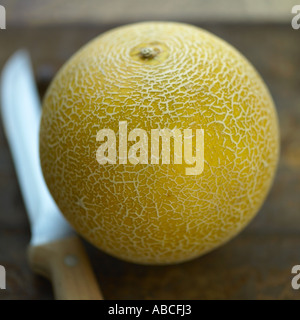 Galia Melone mit Messer Stockfoto
