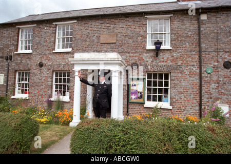 Andy Reid winken auf Passanten, er ist der traditionellen ländlichen Polizei Bobby stationiert in Kingsclere Hampshire UK Stockfoto