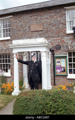 Andy Reid winken auf Passanten, er ist der traditionellen ländlichen Polizei Bobby stationiert in Kingsclere Hampshire UK Stockfoto