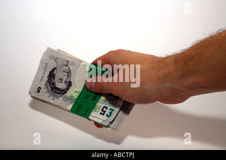 Mann, die Übergabe ein Bündel von fünf-Pfund-Noten Stockfoto