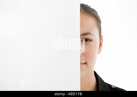 Geschäftsfrau, versteckt hinter einer Trennwand Stockfoto