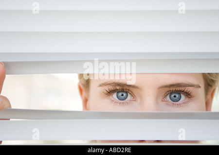 Geschäftsfrau sucht durch Jalousien Stockfoto