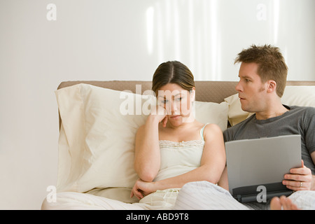 Frau Mann mit Laptop im Bett verärgert Stockfoto
