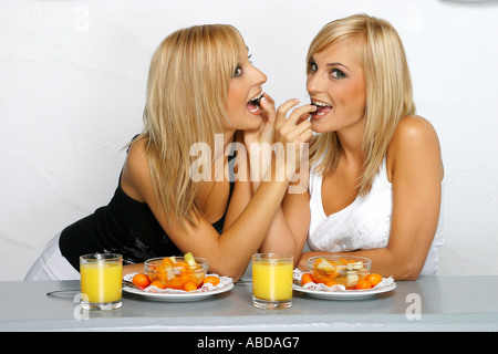Blonde Zwillinge ernähren sich mit Obstsalat Stockfoto
