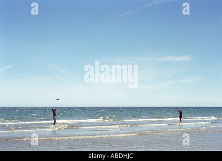 Junges Paar spielen Frisbee im seichten Meer Stockfoto