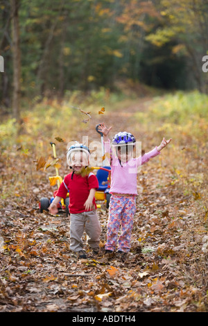 Ein kleiner Junge 2 Jahre und seine Schwester Alter 4 auf ihre Fahrräder Newfields Rail Trail im Newfields NH Herbst Stockfoto