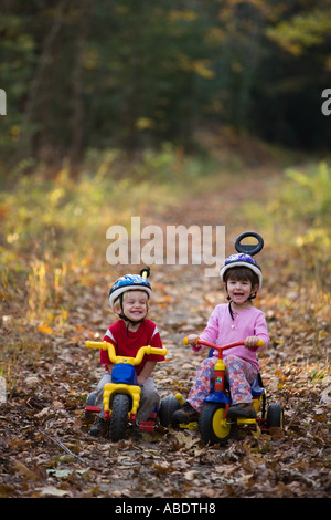 Ein kleiner Junge 2 Jahre und seine Schwester Alter 4 auf ihre Fahrräder Newfields Rail Trail im Newfields NH Herbst Stockfoto