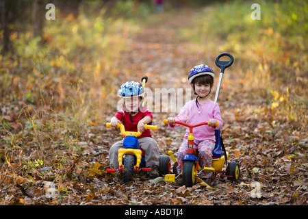 Ein kleiner Junge 2 Jahre und seine Schwester Alter 4 auf ihre Fahrräder Newfields Rail Trail im Newfields NH Herbst Stockfoto