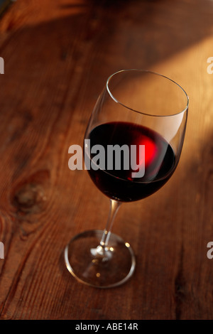Glas Rotwein auf Holztisch Stockfoto