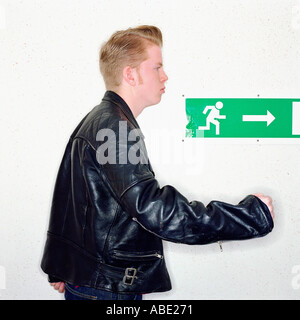 Junge vorbeigehen Notausgangsschild Stockfoto