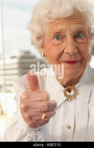 Ältere Frau, die die Daumen aufgeben Stockfoto
