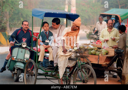 Mit dem Roller unterwegs und Reisen zur Schule mit dem Zyklus Rikscha in Indien Stockfoto