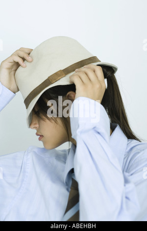 Teenager-Mädchen in Hemd und Krawatte, Hut herunterziehen, über Augen, Porträt Stockfoto