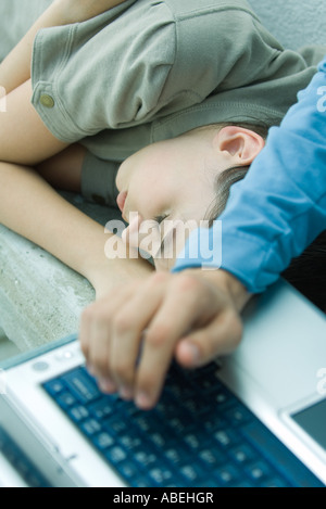 Teen Mädchen hinlegen, während die männlicher Freund Laptop verwendet Stockfoto