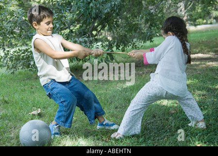 Jungen und Mädchen spielen Tauziehen Stockfoto