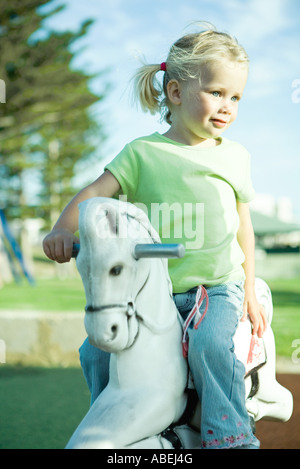 Mädchen auf Spielplatz Schaukelpferd, wegschauen Stockfoto