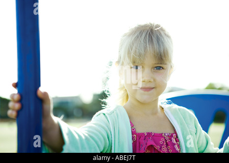 Mädchen auf Spielgeräte, lächelnd in die Kamera Stockfoto