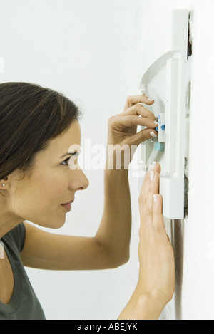 Frau ersetzen Sicherung im Sicherungskasten Stockfoto