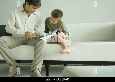 Vater und Sohn lesen Magazin zusammen Stockfoto