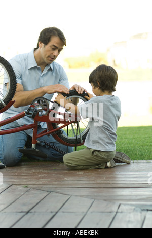 Vater und Sohn zusammen Fahrrad reparieren Stockfoto