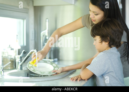 Mutter und Sohn beim Abwasch Stockfoto