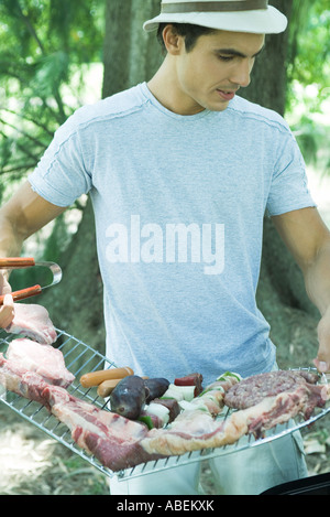 Mann, hält Rack Fleischsorten gegrillt wird Stockfoto