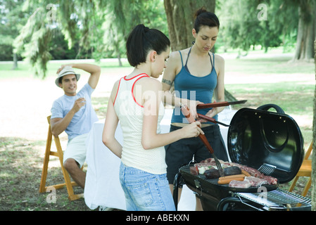 Familie grillen Fleisch am Grill Stockfoto