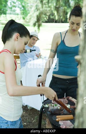 Familie grillen Fleisch am Grill Stockfoto
