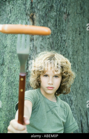 Junge Hot Dog auf Gabel hochhalten Stockfoto