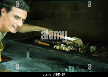 Mann, grillen Fleisch am Grill Stockfoto